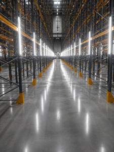 Шлайфан бетон в индустриален склад с метални стелажи